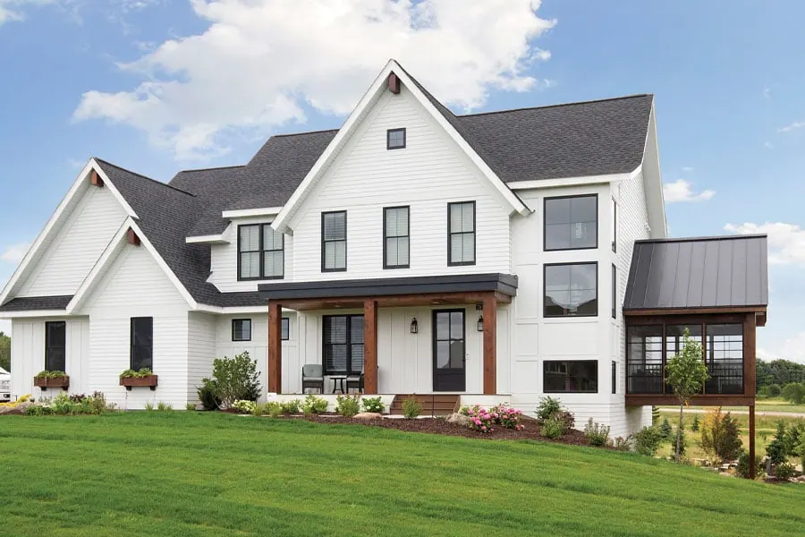White farmhouse exterior with rows of black-framed Andersen windows