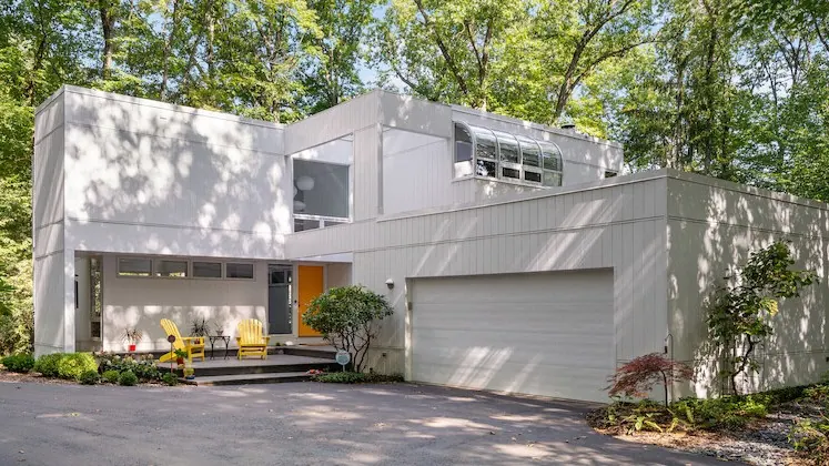 Contemporary white home clad in closely spaced vertical Artisan V-Groove siding