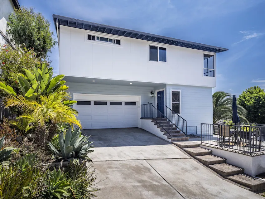White modern home combining vertical Artisan V-Groove siding with architectural panels