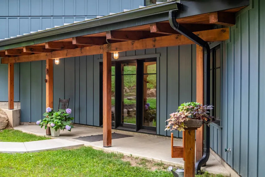 Modern home with deep blue vertical board-and-batten siding and a timber porch